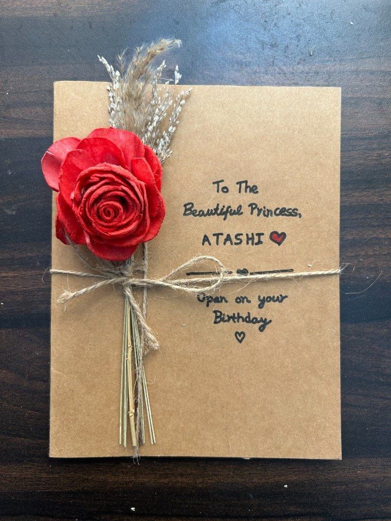 The letter cover — a red rose tied on kraft paper, addressed to Atashi.